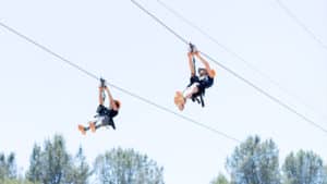 two people ziplining at quarry park adventures, who is now hiring new staff